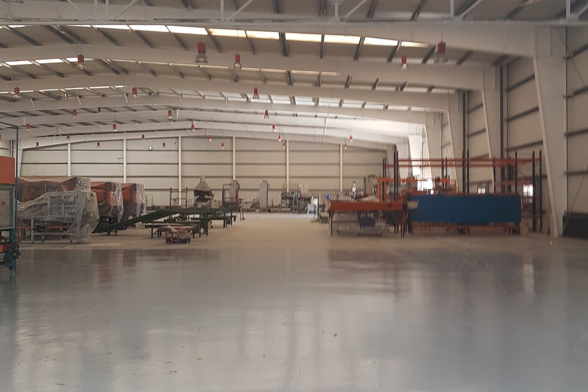 Higiene y cumplimiento normativo en limpieza de naves Nave industrial con suelos limpios y desinfectados